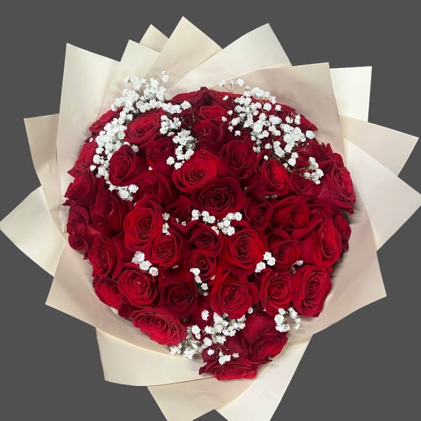 Bouquet of red roses with white baby's breath in cream wrapping