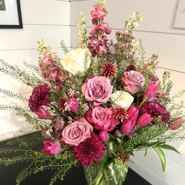 Pink and white mixed flower arrangement in a clear glass vase