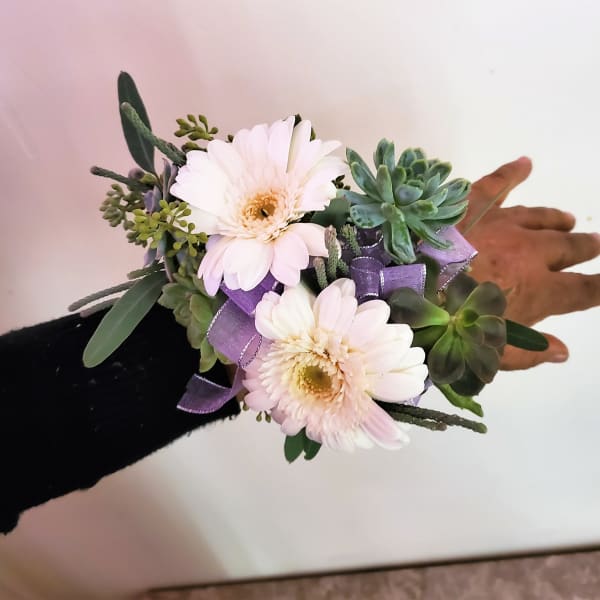 Wrist corsage with pale pink daisies, succulents, and purple ribbon