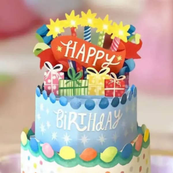 Decorated birthday cake with colorful gifts and a "Happy Birthday" topper