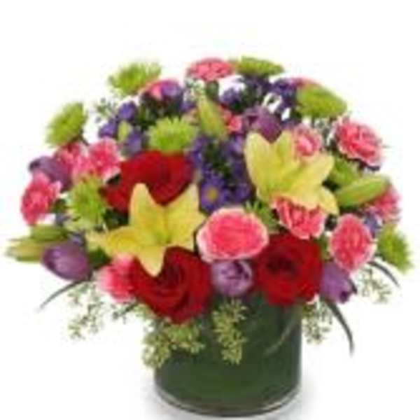 Colorful mixed bouquet in a dark vase with red, pink, purple, and yellow flowers