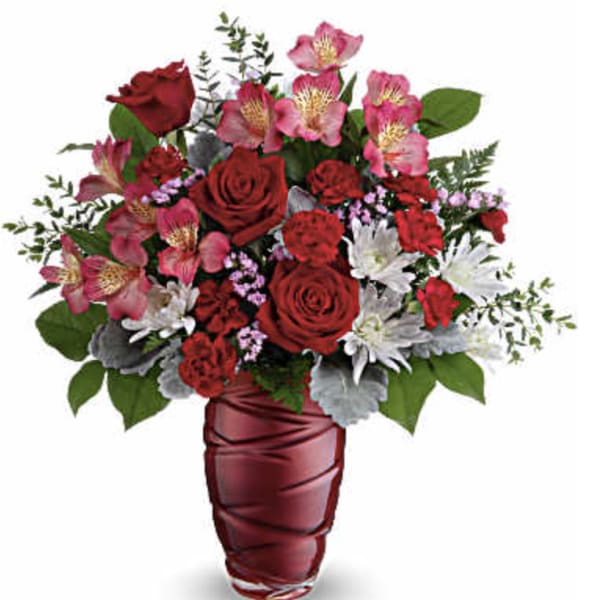 Red roses and pink alstroemeria in a red vase