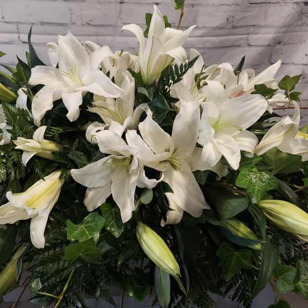 Large white lily arrangement with dense greenery
