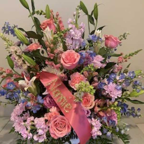 Pink and lavender floral arrangement with a pink ribbon