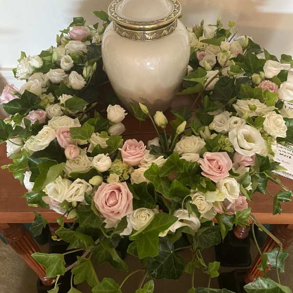 White and pink rose wreath around a ceramic urn