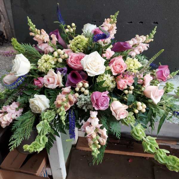 Large pink and white floral arrangement with roses and calla lilies
