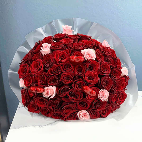 Bouquet of red and pink roses with small red heart decorations