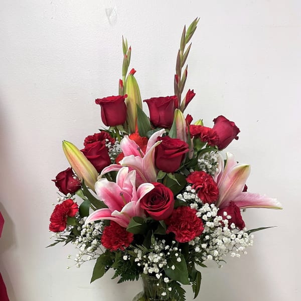 Red roses and pink lilies in a clear glass vase