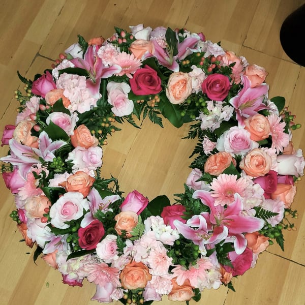 Heart-shaped floral wreath with pink and peach roses and lilies