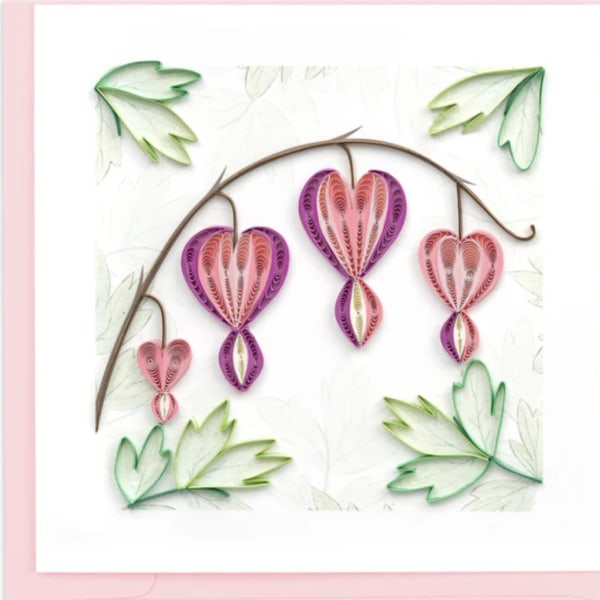Paper quilled hearts hanging from a curved branch on a white background