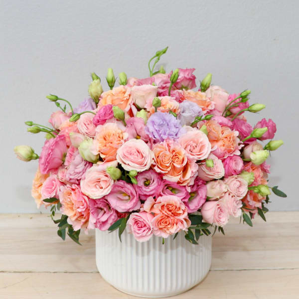 Pink and peach bouquet in a white ribbed vase