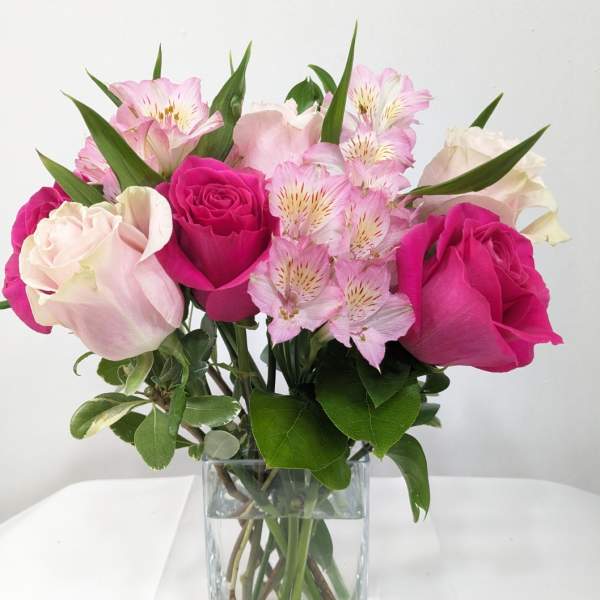 Pink and white roses with alstroemeria in a clear glass vase