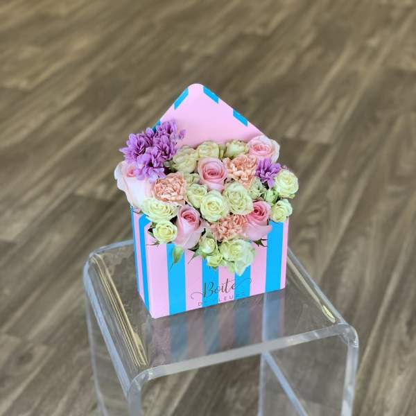 Pastel roses and chrysanthemums in a striped house-shaped box