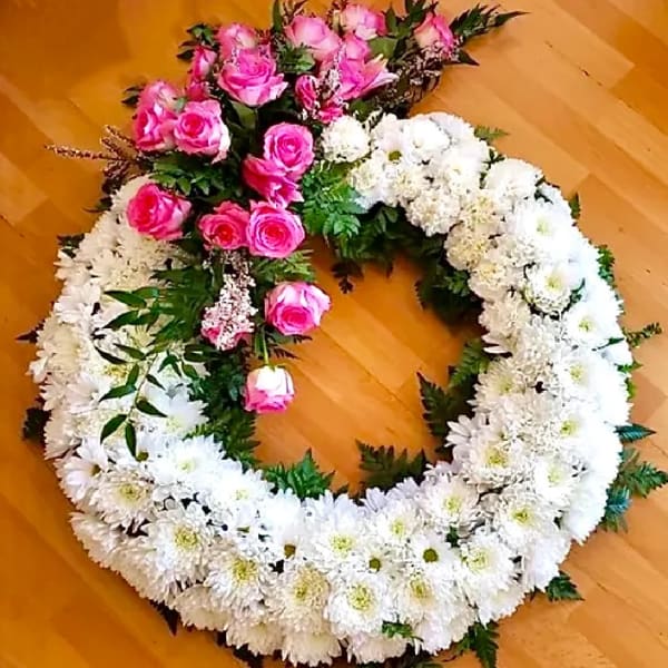 Heart-shaped floral wreath with pink roses and white daisies
