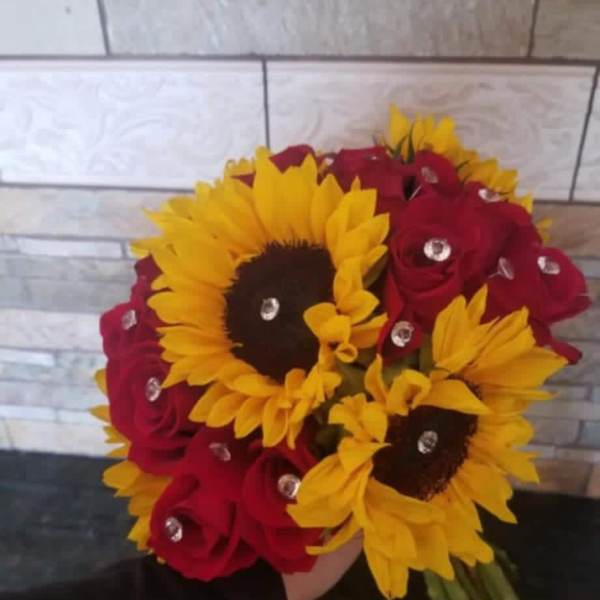 Bouquet of red roses and yellow sunflowers with clear gem accents