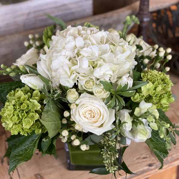 White and green floral arrangement with roses and hydrangeas