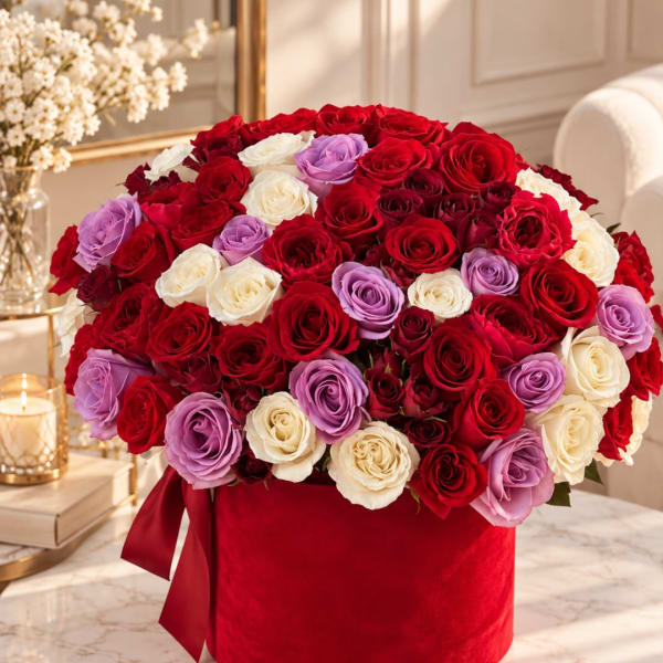 Large bouquet of red, white, and lavender roses in a red box