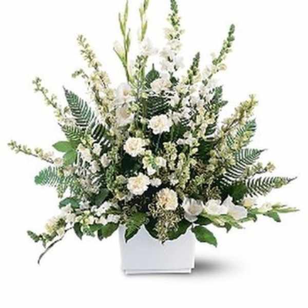 White floral arrangement in a white rectangular vase