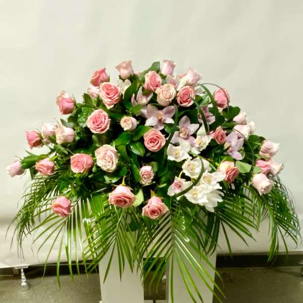Pink roses and white orchids arranged in a large standing display