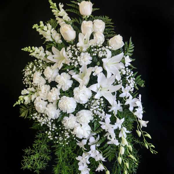 White funeral spray with roses, lilies, orchids, and carnations
