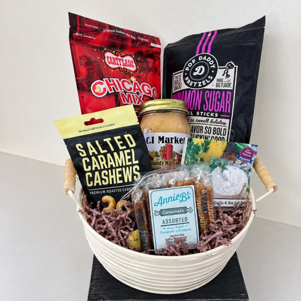Gift basket with assorted snack bags and a jar in a white bowl