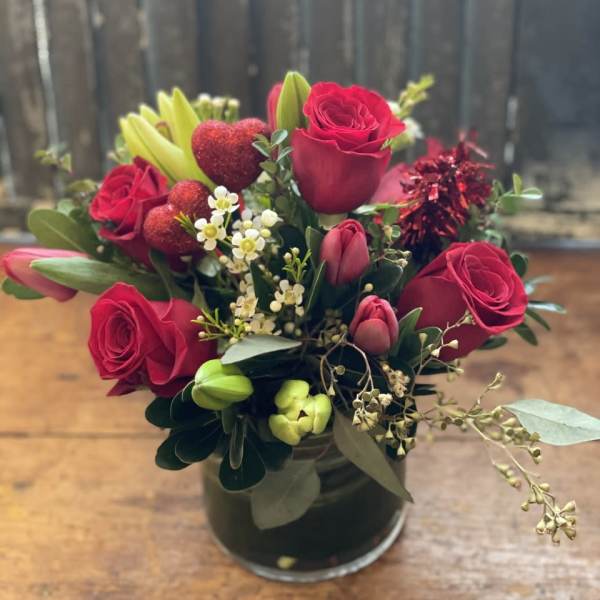Bouquet of red roses and lilies in a glass vase