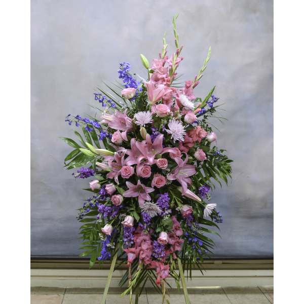 Tall standing spray of pink and purple flowers with lilies and roses