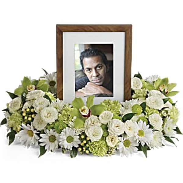 White floral arrangement surrounding a framed photo