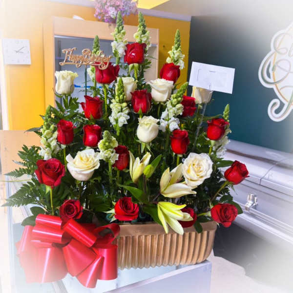 Red and white roses with lilies in a basket, topped with a birthday sign