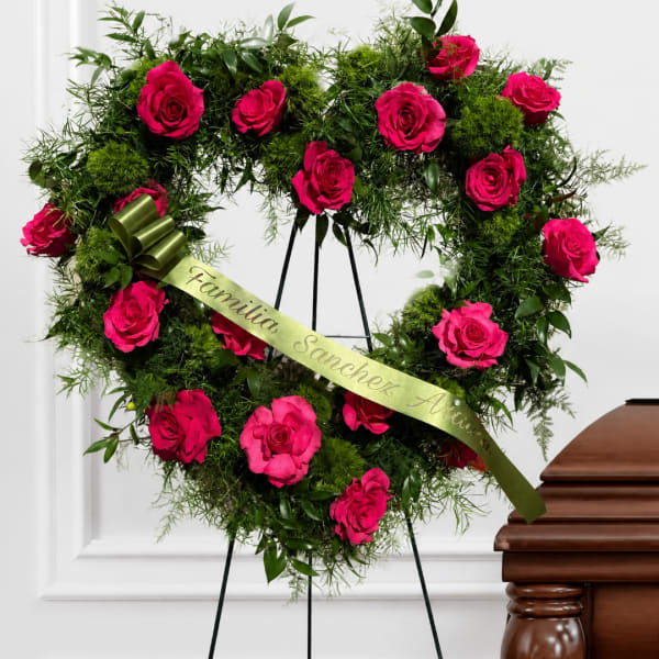 Heart-shaped rose wreath with a ribbon on a stand