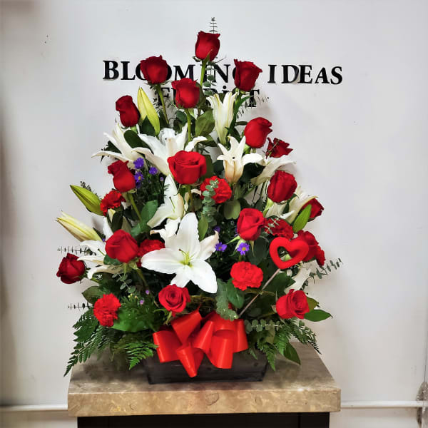 Large red rose and white lily arrangement in a wooden box with a red bow