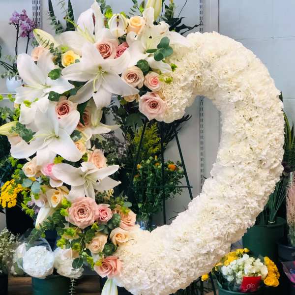 Large floral heart wreath with white lilies, pale roses, and white carnations
