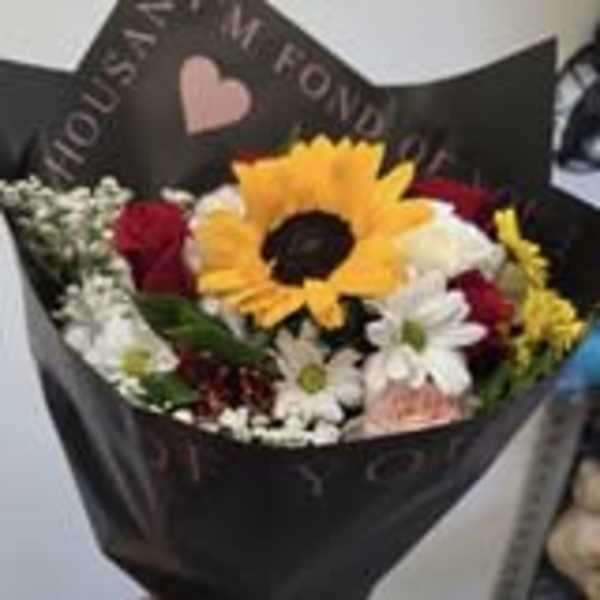 Bouquet with a large yellow sunflower and mixed red and white flowers