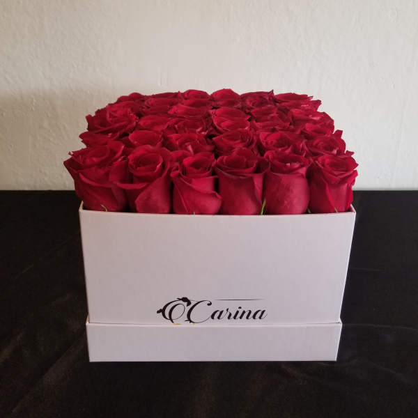 Box of red roses in a white square container
