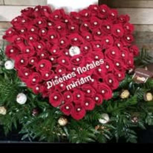 Heart-shaped arrangement of red roses with white accents