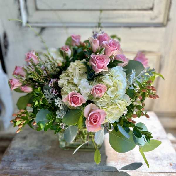 Pink roses and white hydrangeas in a clear glass vase