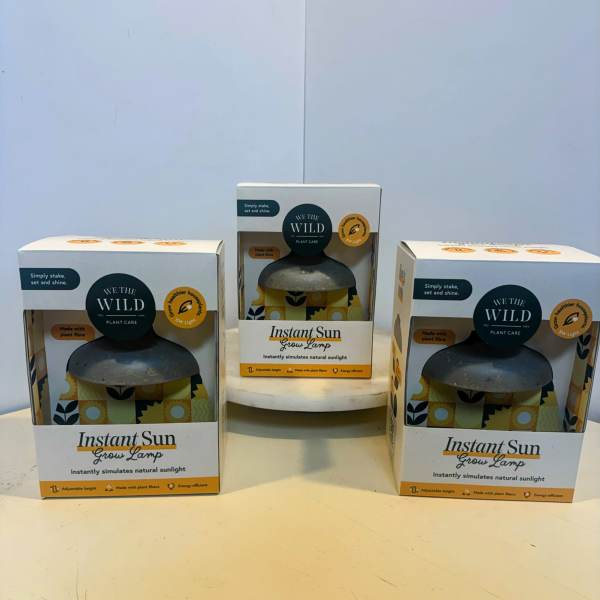 Three boxed grow lamps on a table.