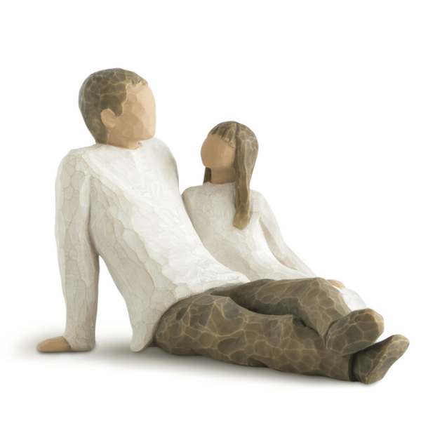 Wooden figurines of a seated man and woman in white clothing