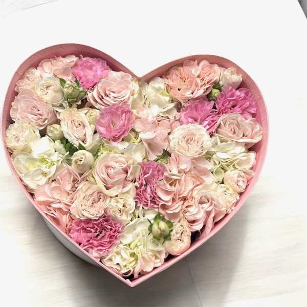 Heart-shaped box filled with pink and cream roses and carnations