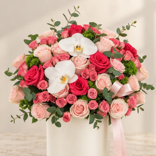 Pink and red rose arrangement in a white box with white orchids