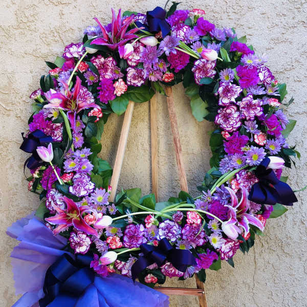 Large purple and pink floral wreath on a wooden easel