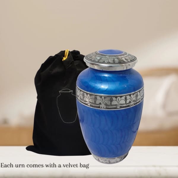 Blue memorial urn with silver detailing beside a black velvet bag