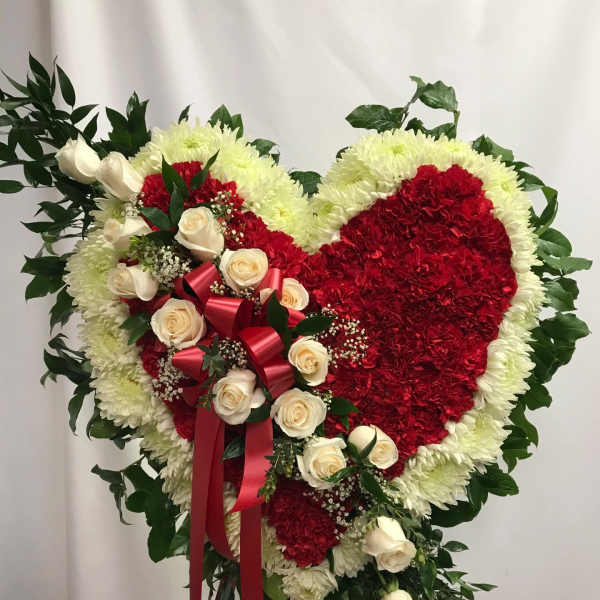 Heart-shaped floral spray with red and white flowers and cream roses