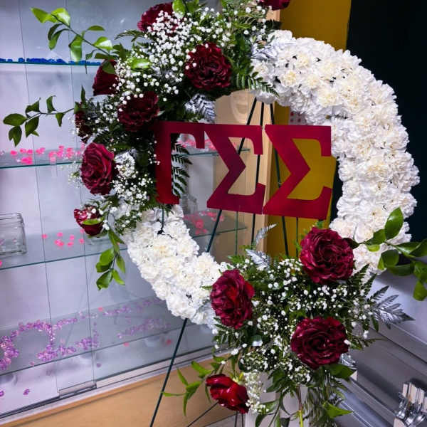 Large floral Greek-letter display with white and burgundy flowers