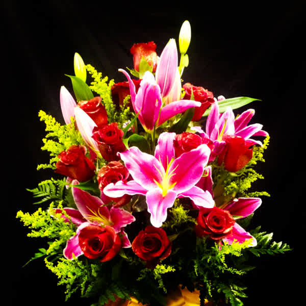 Bouquet of pink lilies and red roses with bright green filler