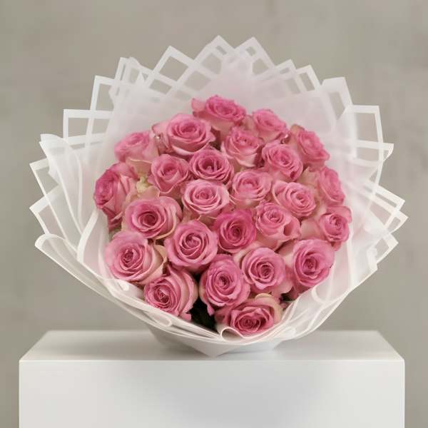 Large bouquet of pink roses wrapped in layered white translucent paper