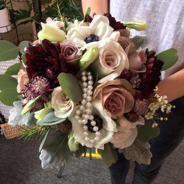 Handheld bouquet of blush and white flowers with pearl strands