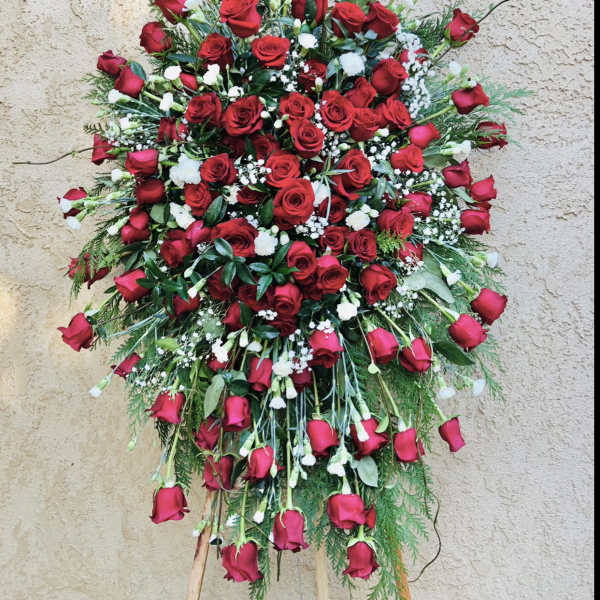 Large standing spray of red roses with white filler flowers