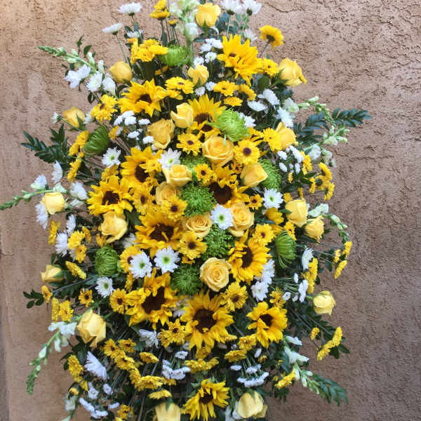 Standing spray of yellow roses, sunflowers, and white daisies
