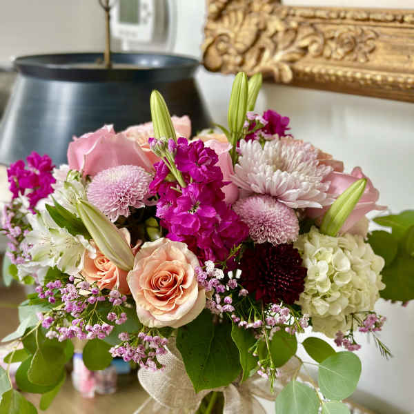 Pink and white mixed bouquet in a glass vase with a burlap ribbon